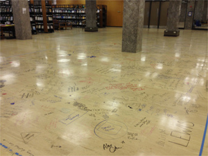 Students sign floor during Farewell to the Floor event in Hesburgh Library