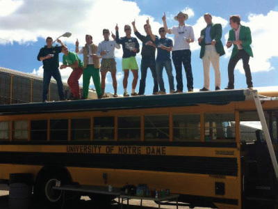Students hold up number 1 while on top of bus