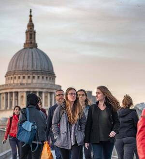 Undergraduates walk across the Millennium Bridge in London